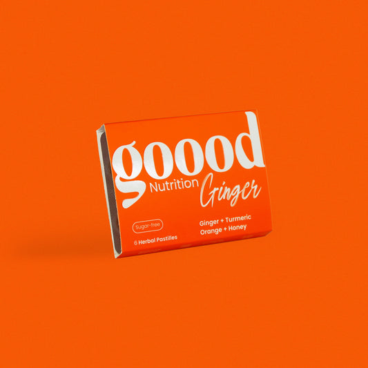 Opened Goood Nutrition Ginger box showing two golden herbal pastilles in blister pack, with a bright orange background.
