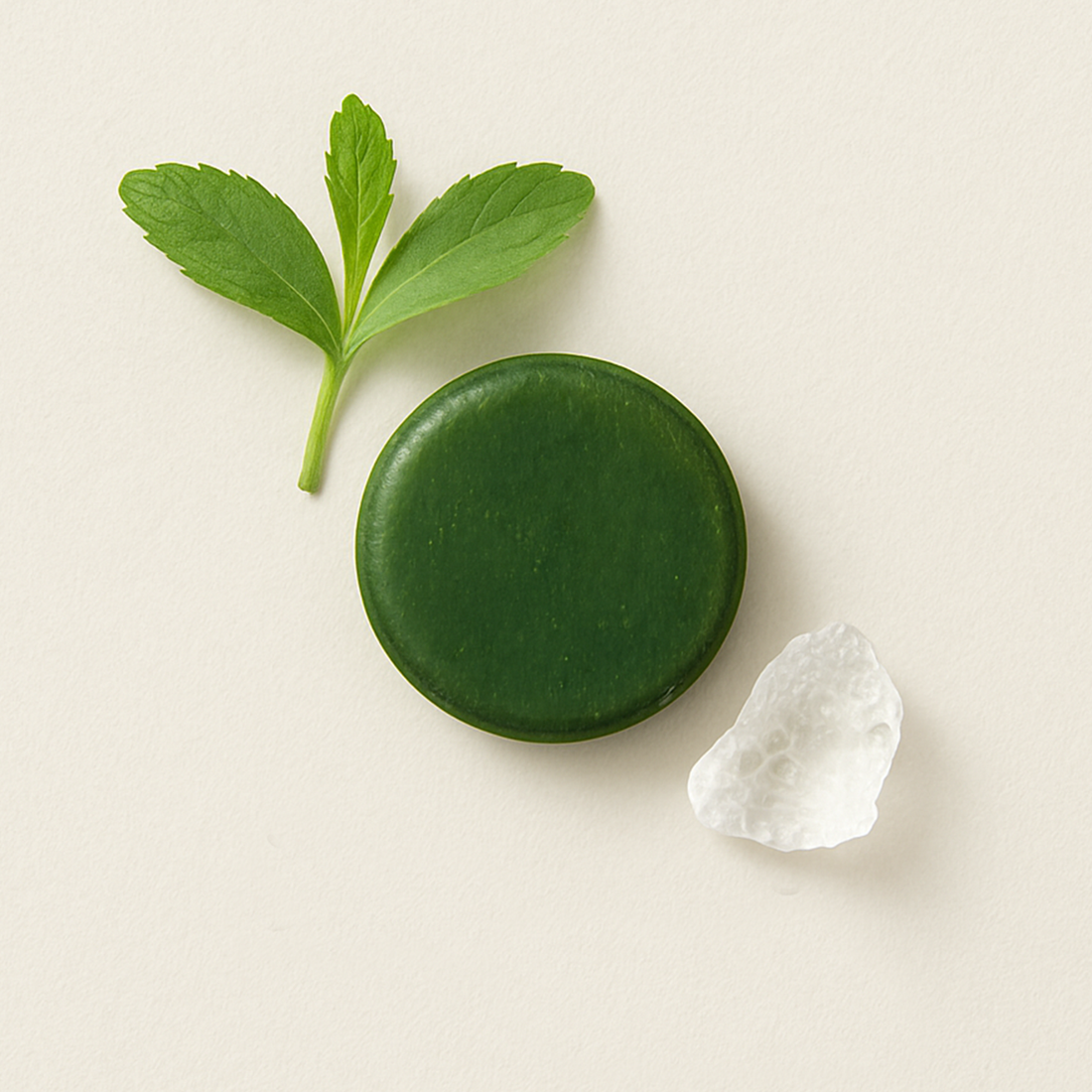 A soft visual of two minimalist sugar-free green pastilles surrounded by subtle plant elements, highlighting the purity of stevia and isomalt.